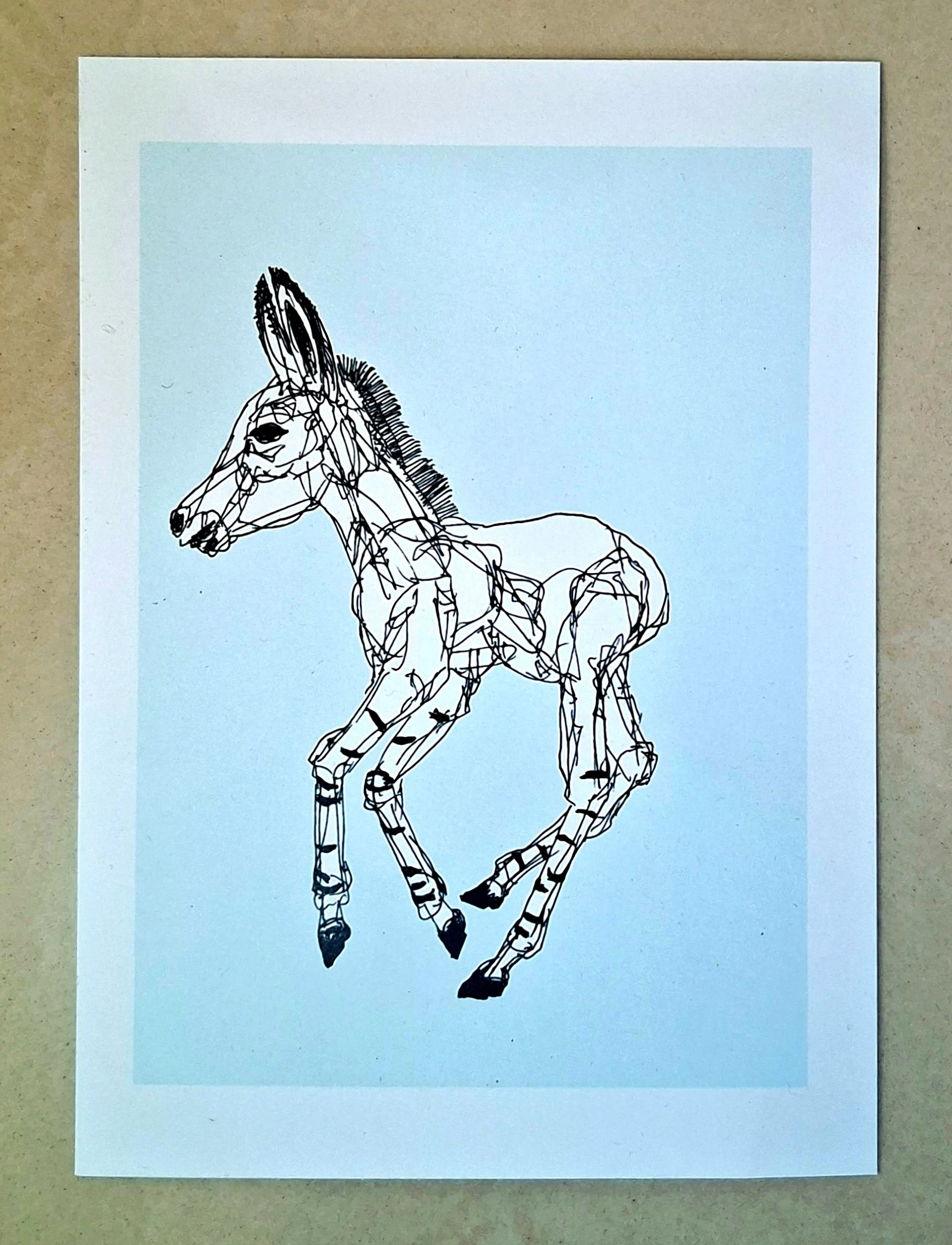 A minimalist kinetic line art sketch of a young donkey or foal by Roi Pajursky. The artwork features intricate, flowing black ink lines on a light blue background, showcasing the rhythmic and expressive drawing technique used in the Living Canvas series.
